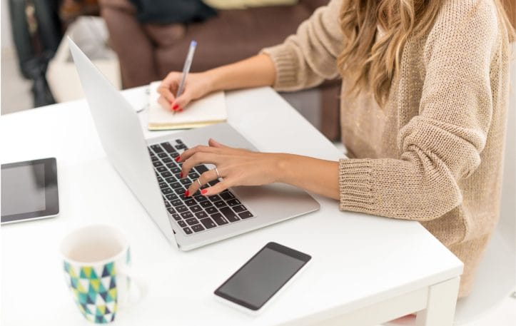 Woman writing text on a laptop